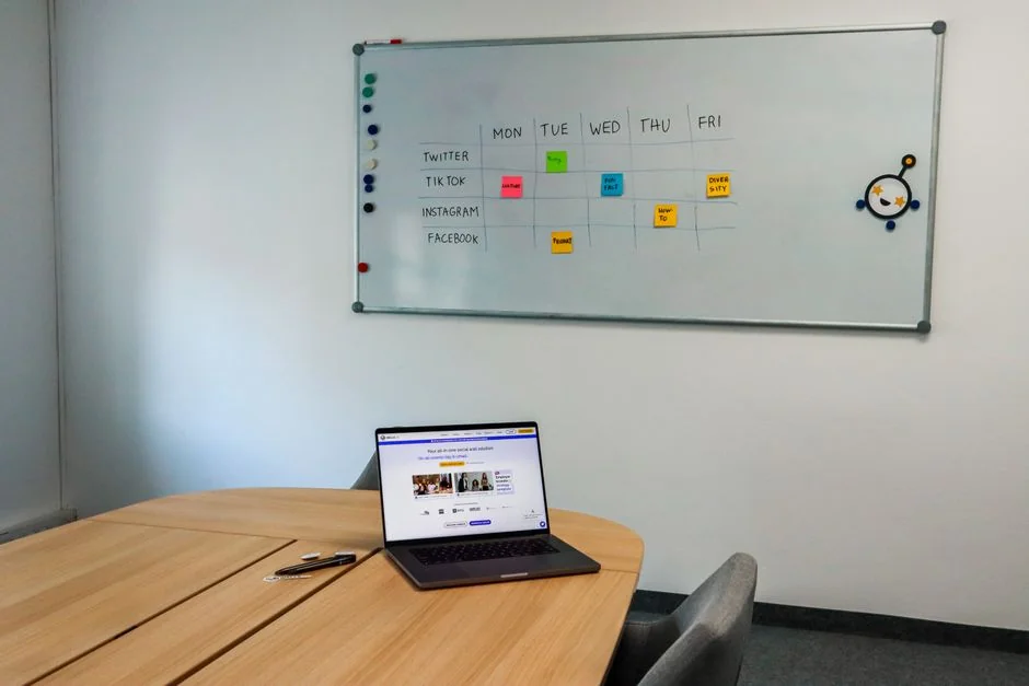 Vue du dessus d’un clavier, d’un agenda avec une note sur le marketing des réseaux sociaux, et d’une tablette posés sur un bureau.